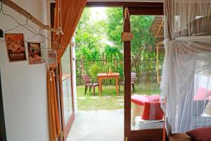 een kamer met een deur naar een patio met een tafel bij Chez Podi Surf Stay in Mirissa