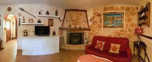 a living room with a stone fireplace and a red couch at Casa Eloísa in Alarcón