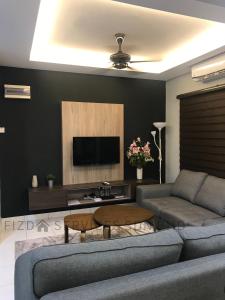 a living room with a couch and a tv at Cozy Apartment @ Hospital Sungai Buloh in Sungai Buluh