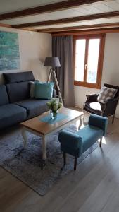 a living room with a blue couch and a coffee table at App. Seeblick Top of Interlaken in Beatenberg