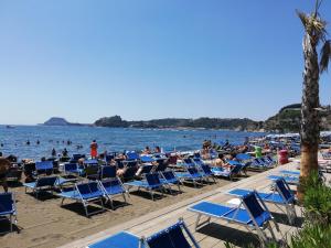 a group of people sitting in chairs on the beach at Hotel Sibilla Residence in Pozzuoli