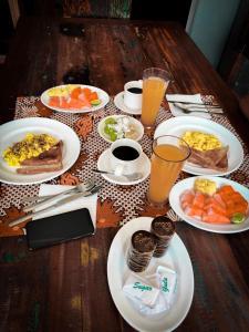 - une table avec des assiettes de produits pour le petit-déjeuner et des boissons dans l'établissement Umah Kayu Ubud, à Ubud