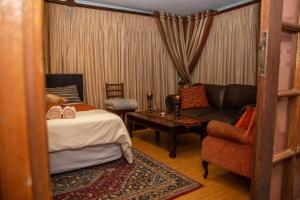 Un dormitorio con una cama, un sofá y una silla. en Blyde Guesthouse, en Benoni 15 fotos más