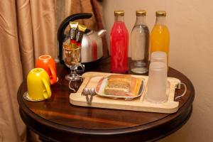una mesa con una bandeja de comida y botellas de zumo en Blyde Guesthouse, en Benoni