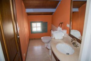 a bathroom with orange walls and a toilet and a sink at Casa Don Din in Cruces