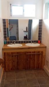 Un baño con dos lavabos y un espejo. en Oiseaux du Paradis, en Le Tampon