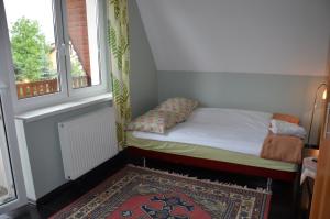 a small bed in a room with a window at A&J Kryspinów in Kryspinów