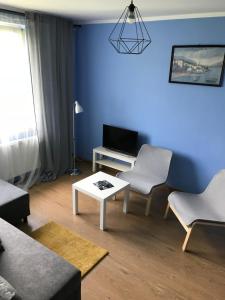 a living room with blue walls and a table and chairs at Tanie Spanie in Międzylesie