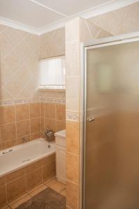 Un baño con bañera, inodoro y lavabo. en Blyde Guesthouse, en Benoni