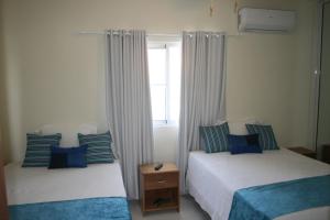 1 dormitorio con 2 camas y ventana en Villa Deluxe Costambar, en San Felipe de Puerto Plata