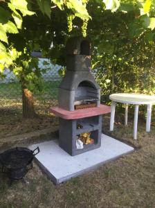 - un four extérieur avec un grill et une table dans l'établissement Dom gościnny Krasne, à Krasnopol