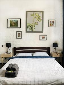 リヴィウにあるAvenue Apartmentsのベッドルーム1室(壁に3枚の写真が飾られたベッド1台付)