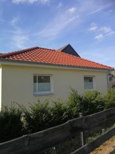 Casa blanca con techo rojo y valla en Apartment Ahrbergen, en Giesen