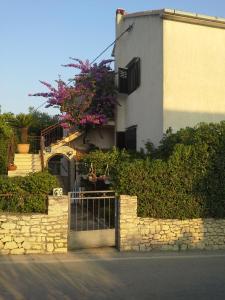 une maison avec une porte et des fleurs sur elle dans l'établissement ROOMS LUCE 2 & Supetar, à Supetar