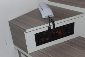 a white phone sitting on top of a counter at Hotel Cumbica in Guarulhos