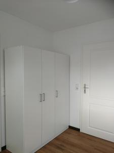 Pokój z białymi szafkami i białą ścianą w obiekcie Apartment Ahrbergen w mieście Giesen