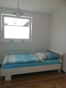 Bett in einem Zimmer mit Fenster in der Unterkunft Apartment Ahrbergen in Giesen