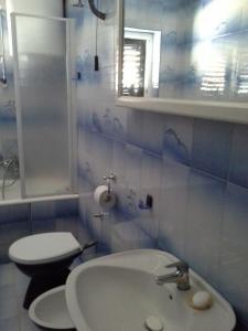 een badkamer met een witte wastafel en een toilet bij ROOMS LUCE 2 & Supetar in Supetar