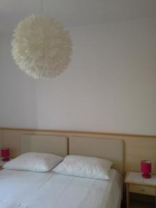 una camera con un letto con due cuscini bianchi di ROOMS LUCE 2 & Supetar a Supetar (San Pietro di Brazza)