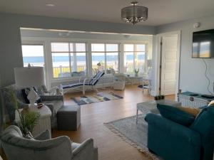 a living room with couches and chairs with a view of the ocean at The York in Old Orchard Beach