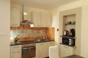 uma cozinha com um lavatório e um micro-ondas em Logement, classé 3 étoiles, de 42 m2 tout confort en campagne pour un couple em Cahuzac-sur-Vère