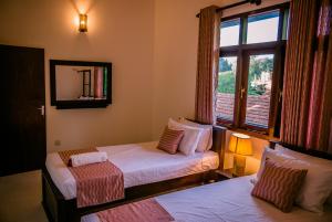 sypialnia z 2 łóżkami i oknem w obiekcie BIVORA Villa w Negombo