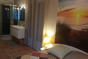 卡于扎克叙尔韦尔Logement avec piscine, classé 3 étoiles, de 42 m2 tout confort au calme pour un couple的卧室里有一张床，墙上挂着一幅画