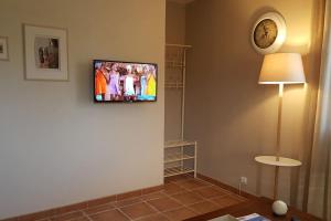 Logement avec piscine, classé 3 étoiles, de 42 m2 tout confort au calme pour un couple的电视和/或娱乐中心