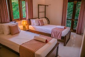 ネゴンボにあるBIVORA Villaのベッド2台と窓のある寝室