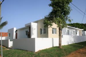 una casa con paredes blancas y un árbol en Villa Deluxe Costambar en San Felipe de Puerto Plata