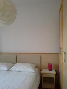 a bedroom with a bed and a table with a red candle at ROOMS LUCE 2 & Supetar in Supetar