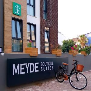 un vélo garé à côté d'un panneau indiquant les suites meggie dans l'établissement Meyde Boutique Suites, à Antalya