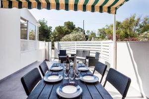 a wooden table and chairs on a patio at Chalet tout confort ideal famille enfants tennis piscine plage in El Moncayo