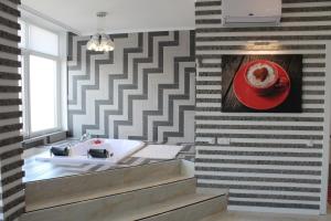 a bathroom with a sink and a red hat on the wall at M&P VIP Appartments in Arkadia in Odesa +88 photos
