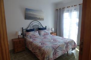 Un dormitorio con una cama grande y una ventana en El Faro, en Playa Blanca