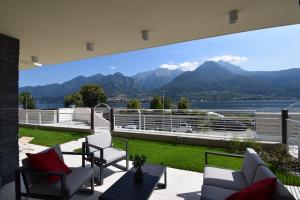 een patio met uitzicht op het water en de bergen bij Appartamento Narciso - Facing lake Como Bellagio Wild Flowers in Oliveto Lario
