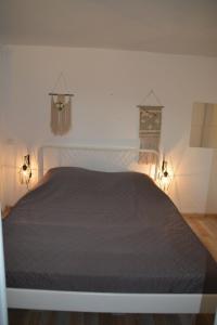 ル・ラヴァンドゥーにあるMaison à Saint Clair au Lavandou 4 personnesのベッドルーム1室(黒いベッド1台、2つの照明付)