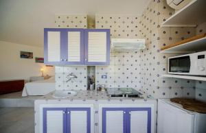 a kitchen with purple cabinets and a sink at La Rotonda in Anacapri