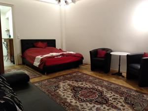 a bedroom with a bed and two chairs and a rug at Gyöngyi apartman in Budapest