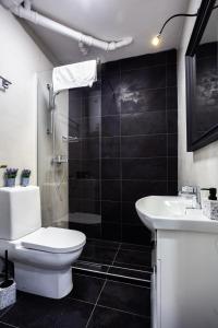 a bathroom with a toilet and a sink and a shower at Apartment Sfera in Novi Sad +33 photos