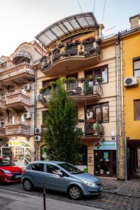 a blue car parked in front of a building at Apartment Sfera in Novi Sad