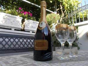 a bottle of wine sitting next to two wine glasses at Apartmani Ivona in Budva