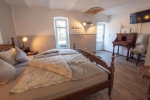 a bedroom with a bed and a piano at Pension Schneiderstübchen Hambergen in Hambergen