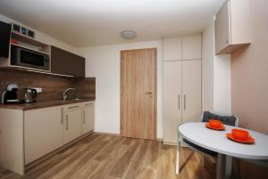 a kitchen with a white table and a table and a kitchen with a counter at Apartmán MH in Břeclav