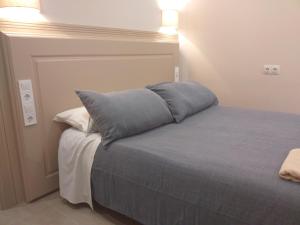 Una cama con una almohada azul encima. en Apartamentos AS Malaga centro historico, en Málaga