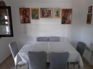 a dining room table with chairs and pictures on the wall at Apartmani Ivona in Budva +29 photos