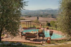 a patio with a table and chairs next to a pool at Podere La Ciabatta in Casole dʼElsa