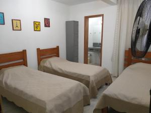 a room with two beds and a mirror at Thiferer Hostel in Viçosa