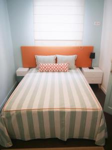 a bedroom with a bed with an orange and white stripes at Cangosta House in Fão