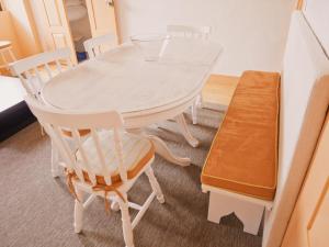 una mesa de comedor blanca con 2 sillas y un banco en Cangosta House, en Fão